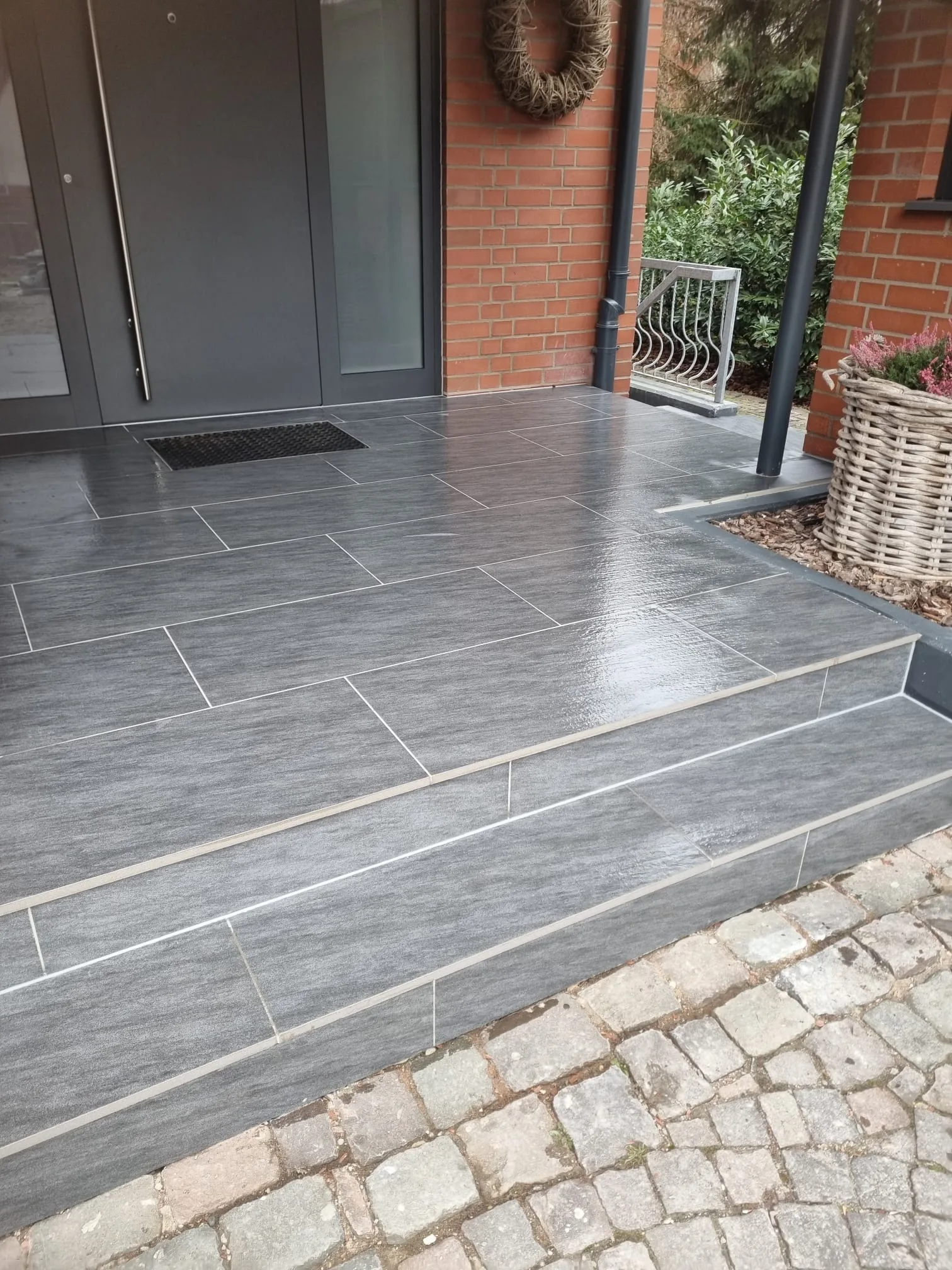 Moderne Terrasse mit dunklen Natursteinfliesen